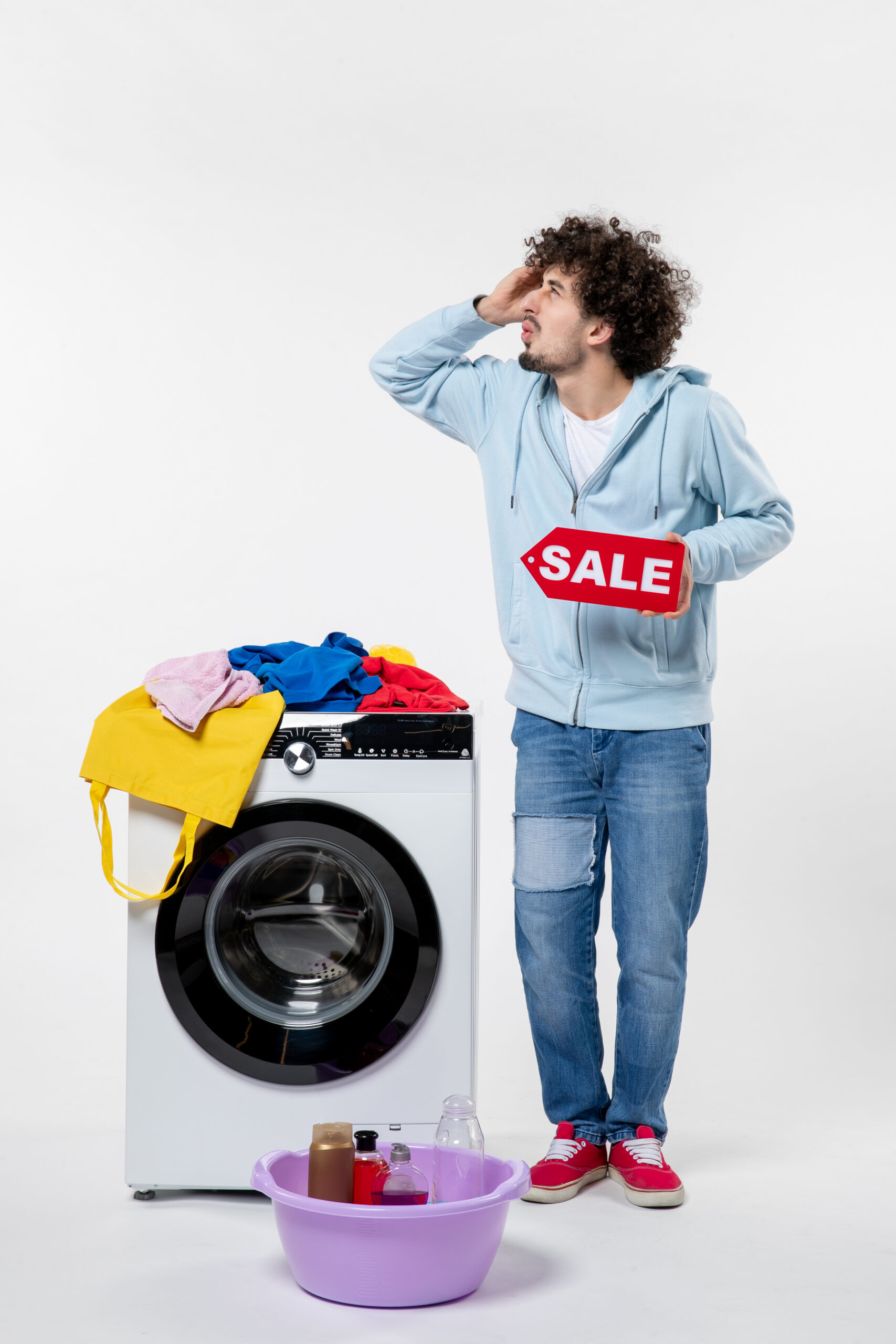 front view young male with washer holding red sale banner white wall